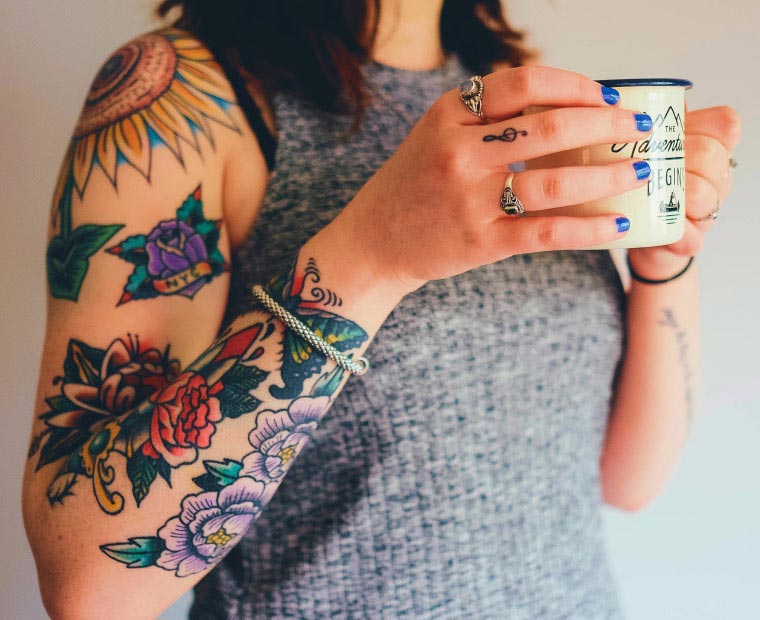 Woman with Tattooed Arms Drinking Coffee